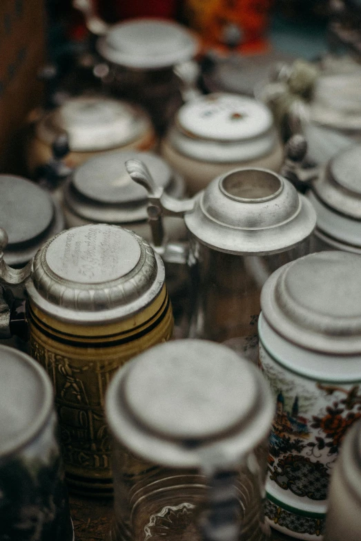 a bunch of jars sitting on top of a table, german, lot of details, up close, stainless steel
