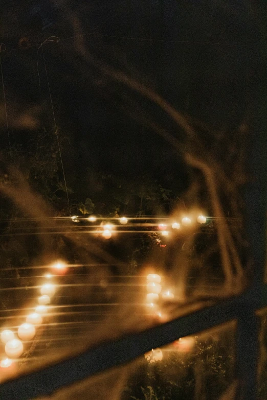 a bunch of candles that are on a window sill, an album cover, inspired by Elsa Bleda, unsplash, on a bridge, low quality grainy, car lights, wires