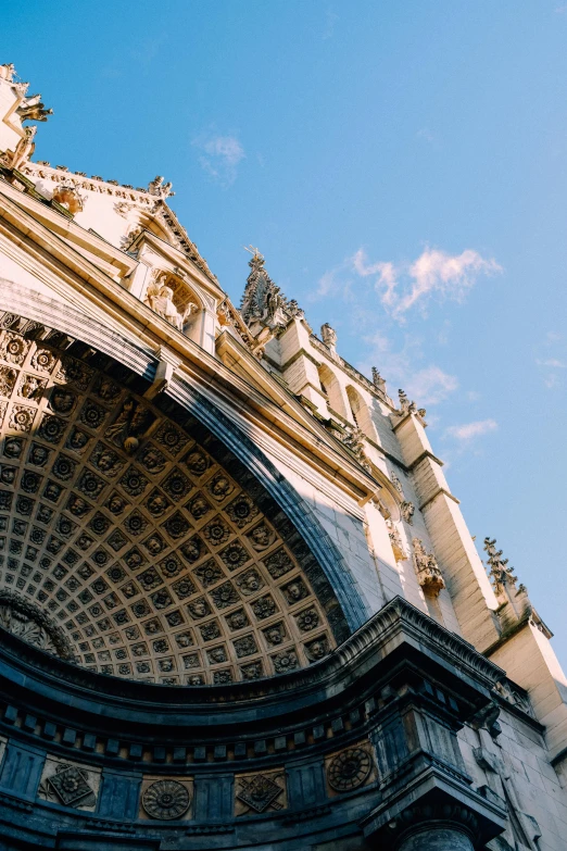 a very tall building with a clock on it's side, by Matteo Pérez, trending on unsplash, baroque, tall arched stone doorways, seville, wide angel shot from below, simple gable roofs