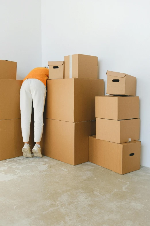 a person leaning against a stack of cardboard boxes, trending on pexels, freaking out, faceless human figures, kailee mandel, white box