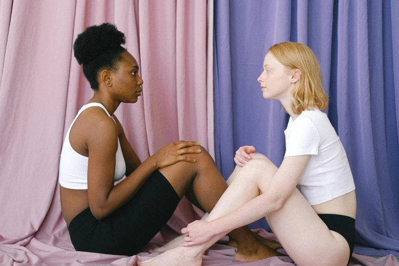 a couple of women sitting on top of a bed, inspired by Vanessa Beecroft, trending on pexels, iridescent skin, calmly conversing 8k, black teenage girl, anatomically incorrect