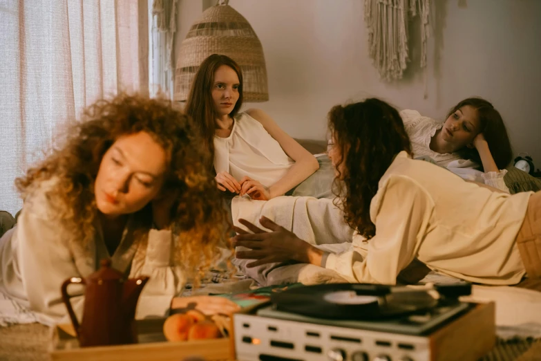 a group of people sitting on top of a bed, inspired by Nan Goldin, trending on pexels, renaissance, people at the table, musician, suspiria, sitting in a lounge