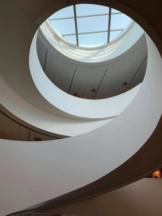 a spiral staircase in a building with a skylight, an abstract sculpture, inspired by Douglas Bourgeois, trending on unsplash, light and space, brooklyn museum, alvar aalto, photo taken in 2018, worm\'s eye view