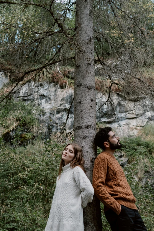 a man and a woman standing next to a tree, an album cover, by Else Alfelt, pexels contest winner, in the swiss alps, thoughtful pose, brown, comfortable