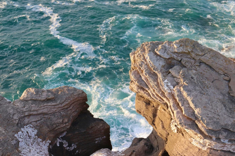 a man standing on top of a cliff next to the ocean, water swirling, limestone, gigapixel photo, youtube thumbnail