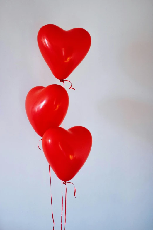 a bunch of red balloons in the shape of a heart, a picture, pexels, romanticism, tall shot, soft vinyl, 3/4 side view, hegre