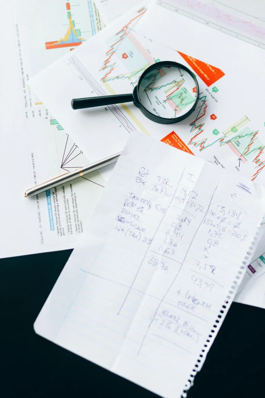 a table topped with lots of papers and a magnifying glass, by Carey Morris, trending on pexels, equations, whiteboards, schematic in a notebook, full product shot