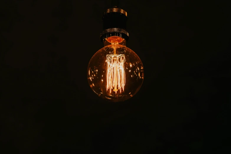 a light bulb lit up in the dark, inspired by Elsa Bleda, unsplash, brown, volumetric light from below, instagram post, taken in the late 2000s
