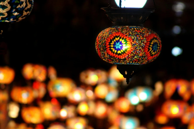 a group of colorful lights hanging from a ceiling, a mosaic, by Meredith Dillman, pexels, arabesque, on a candle holder, travel, orange teal lighting, serene