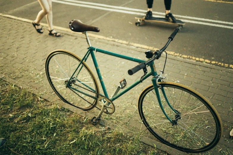 a green bicycle parked on the side of a road, an album cover, by Lubin Baugin, pexels contest winner, slightly tanned, mechanics, sport, people watching around