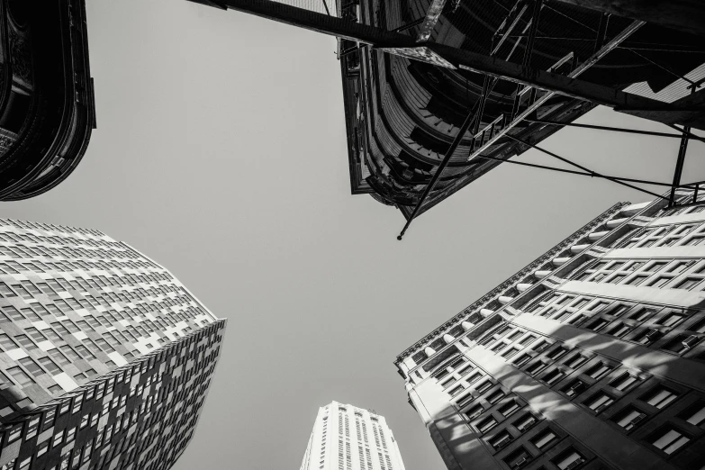 a black and white photo of tall buildings, by Adam Marczyński, unsplash contest winner, view from below, skyscrapers and flying cars, unsplash photo contest winner, three fourths view