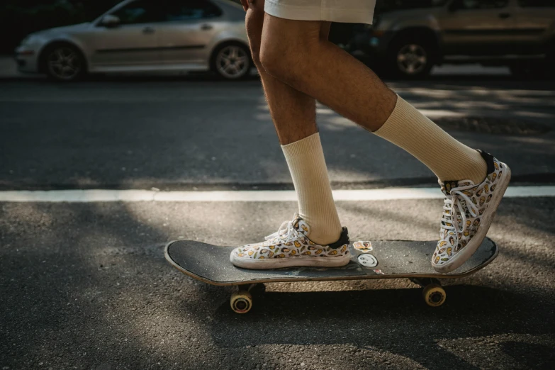 a man riding a skateboard down a street, by Niko Henrichon, trending on pexels, socks, on a hot australian day, off - white collection, complexly detailed