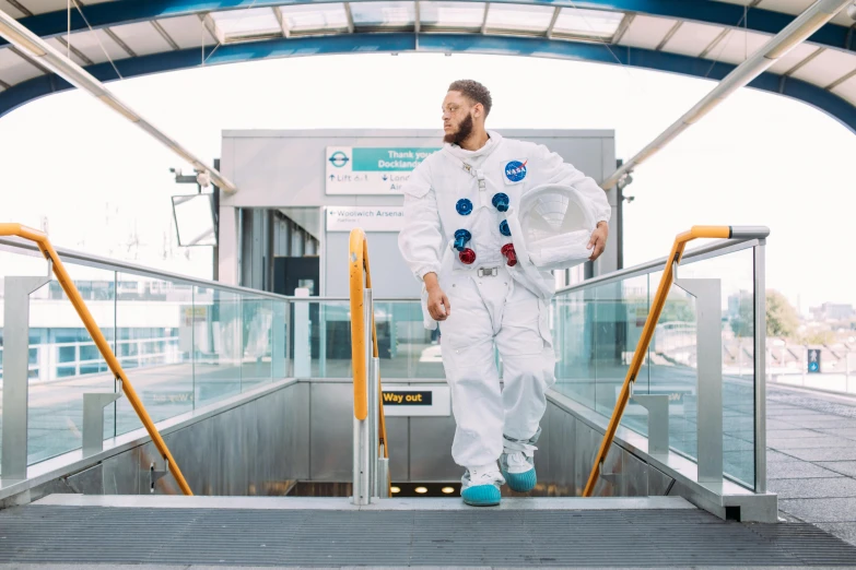 a man in a space suit walking down an escalator, inspired by Jules Tavernier, pexels contest winner, afrofuturism, pete davidson walking a kangaroo, standing on the moon, action bronson, monorail station