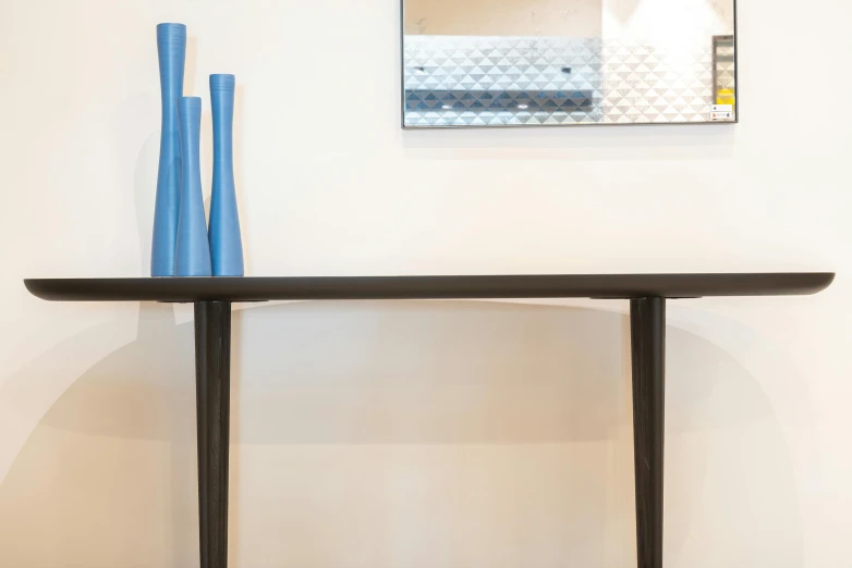 a table with two blue vases on top of it, by Carey Morris, pexels contest winner, minimalism, the console is tall and imposing, vanara, detail shot, blue and black scheme