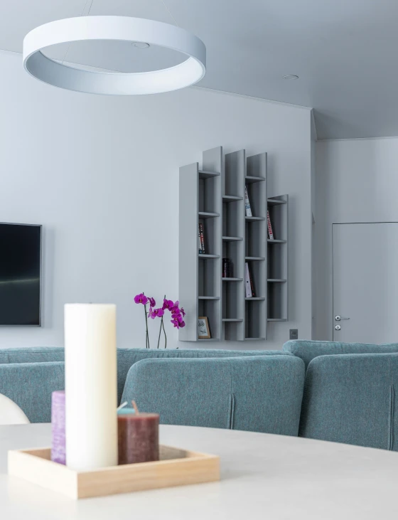 a living room filled with furniture and a flat screen tv, a 3D render, by Adam Marczyński, pexels contest winner, light and space, spiral shelves full of books, white grey blue color palette, purple accent lighting, serene and peaceful style