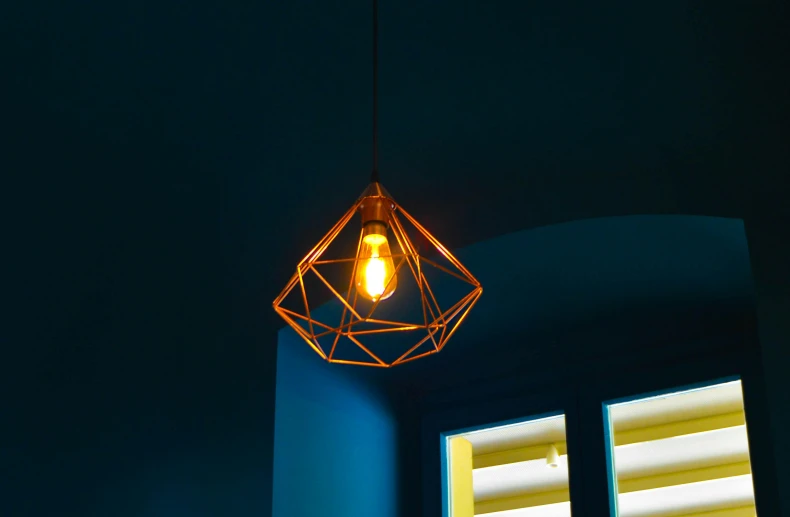 a light that is on in a room, inspired by Joseph Wright of Derby, pexels contest winner, light and space, copper veins, polyhedron, teal orange, single light