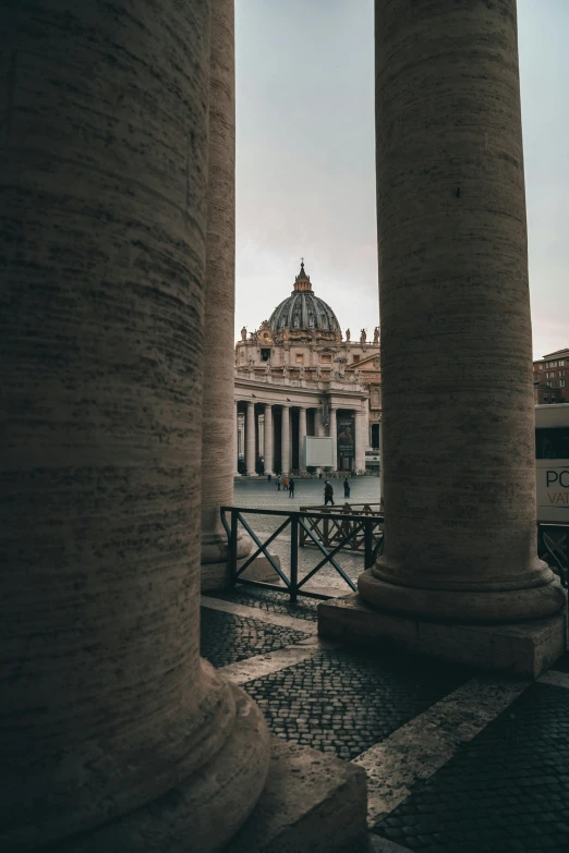 a couple of columns sitting next to each other, by Cagnaccio di San Pietro, pexels contest winner, neoclassicism, dome, from afar, kneeling before the pope, seen from outside