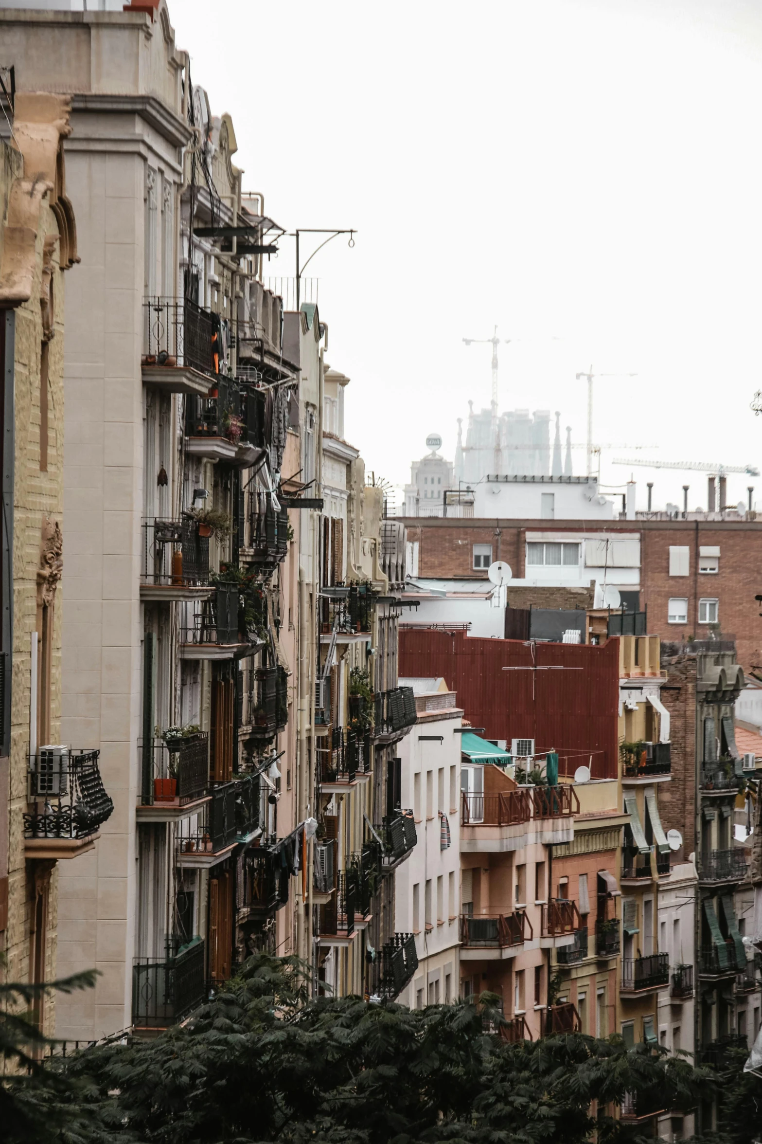 a city street filled with lots of tall buildings, inspired by Modest Urgell, balcony, preserved historical, grey, exterior