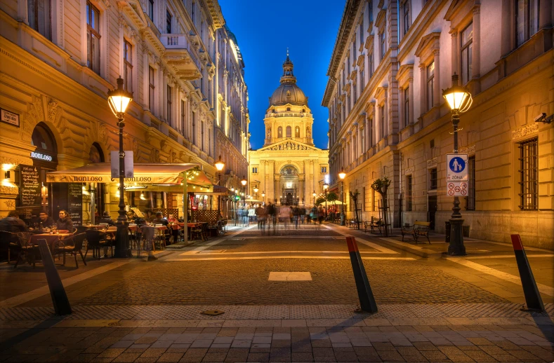 a city street filled with lots of tall buildings, a photo, by Konrad Witz, shutterstock, renaissance, on a street at night, budapest, pantheon, thumbnail