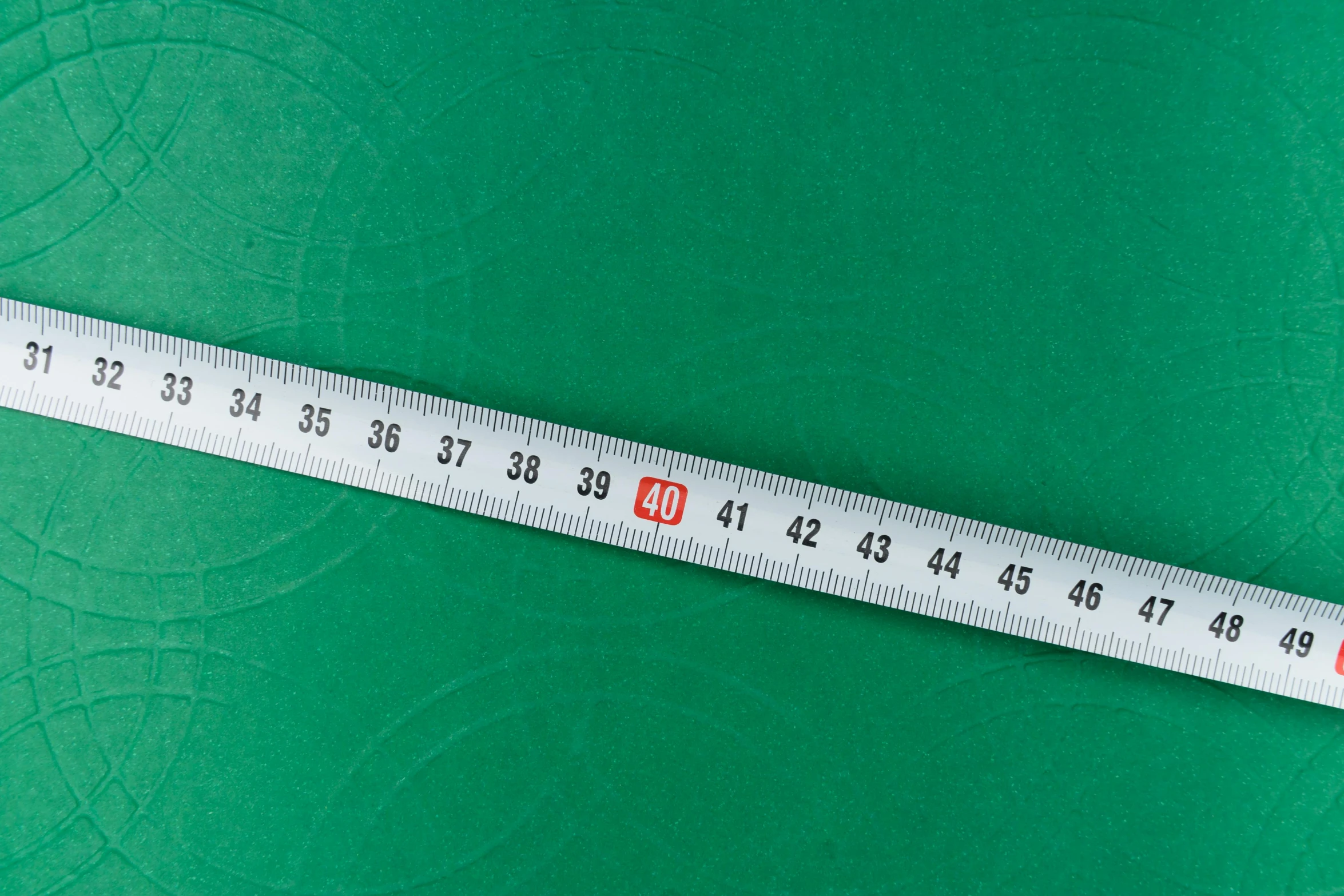 a close up of a measuring tape on a green surface, nonagon infinity, heian, 2 0 0 mm wide shot, large-scale