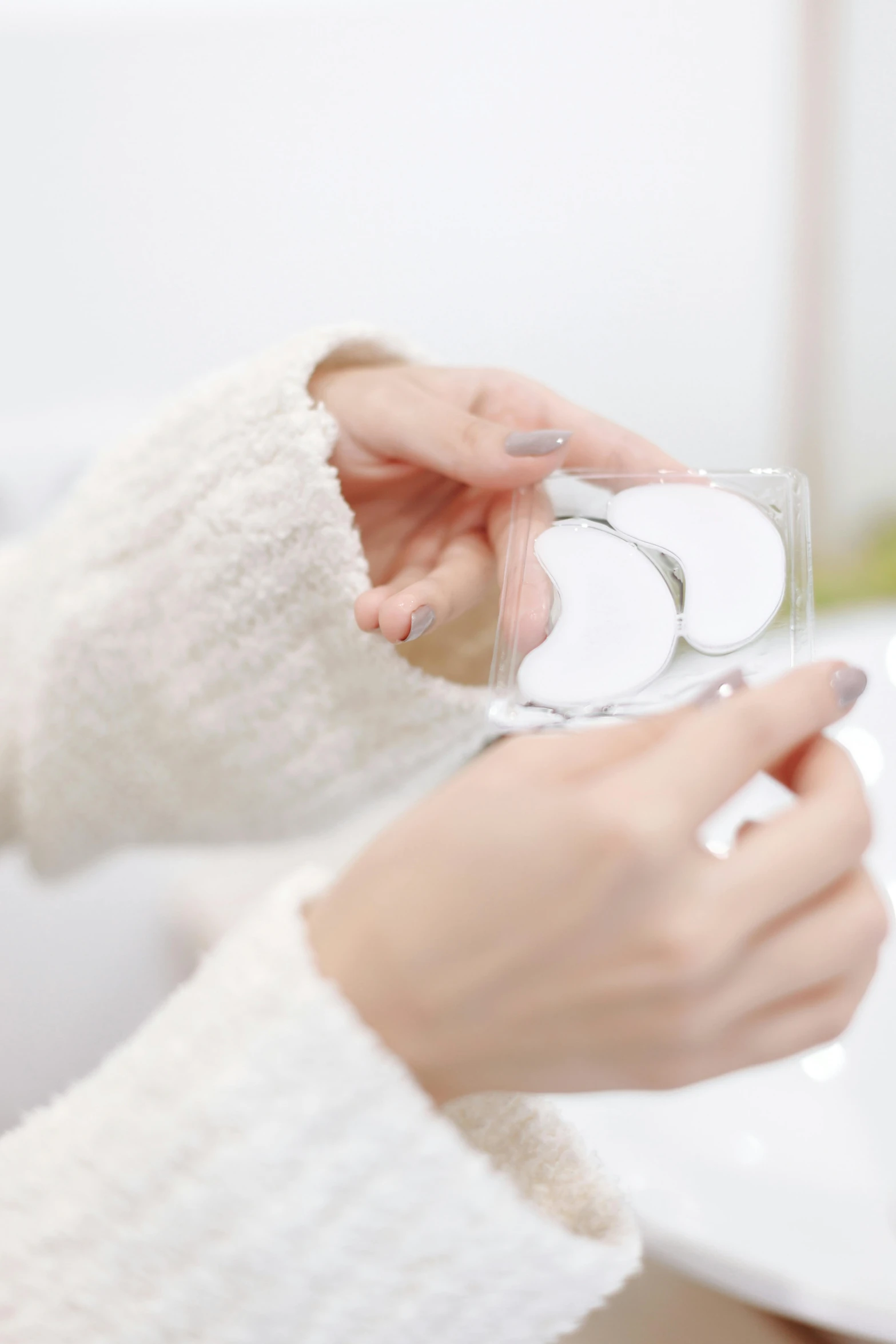 a close up of a person holding a glass of water, with a mirror, soft pads, white and silver, white