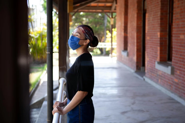 a woman standing on a sidewalk wearing a face mask, happening, calarts, portrait of chun li, looking outside, college