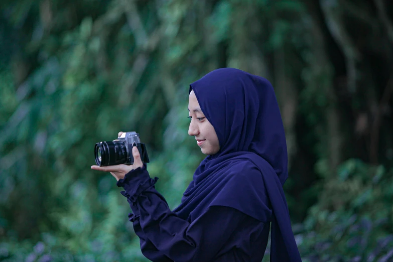 a woman taking a picture with a camera, a picture, inspired by Nazmi Ziya Güran, sumatraism, purple, navy, hasselblad quality, islamic