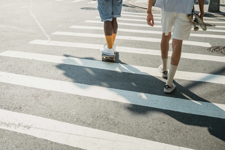 a couple of people that are walking across a street, trending on unsplash, hyperrealism, striped socks, summer light, ignant, skateboarding