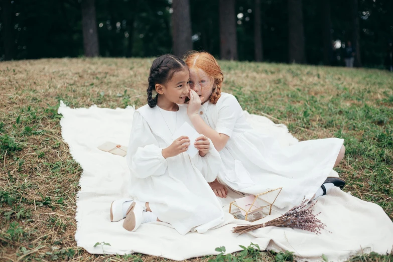 two little girls sitting on a blanket in a field, inspired by Kate Greenaway, pexels contest winner, dressed in white robes, photoshoot for skincare brand, on a white table, people on a picnic