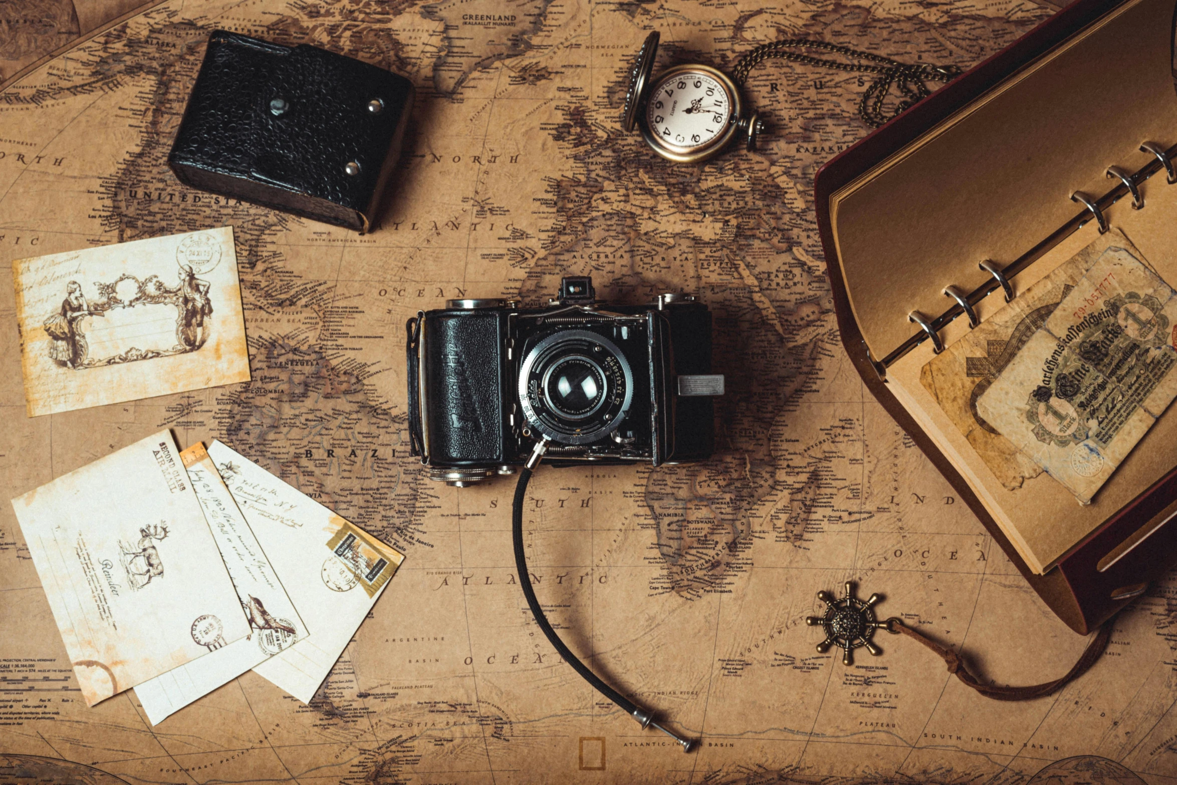 an old camera sitting on top of a map, a picture, pexels contest winner, 🕹️ 😎 🔫 🤖 🚬, spotlight, brown, several continents