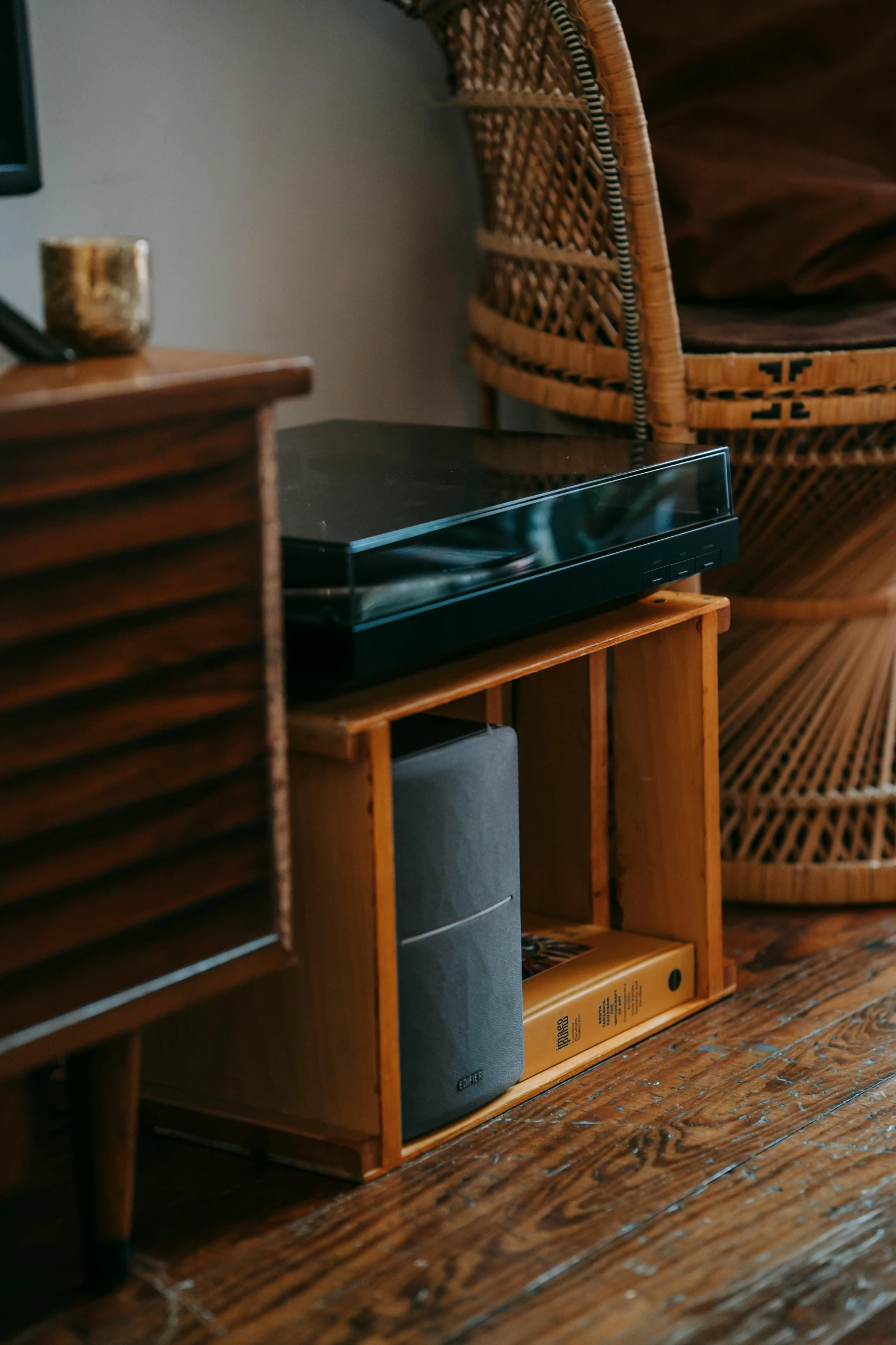 a cat sitting on top of a wooden floor next to a chair, an album cover, unsplash, subwoofer, alexa mini, japanese collection product, detailed product image