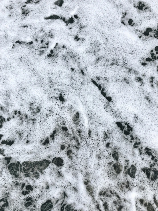 a black and white photo of a body of water, an album cover, inspired by Vija Celmins, trending on pexels, lyrical abstraction, covered in white flour, bubbles everywhere, colored marble, high angle close up shot