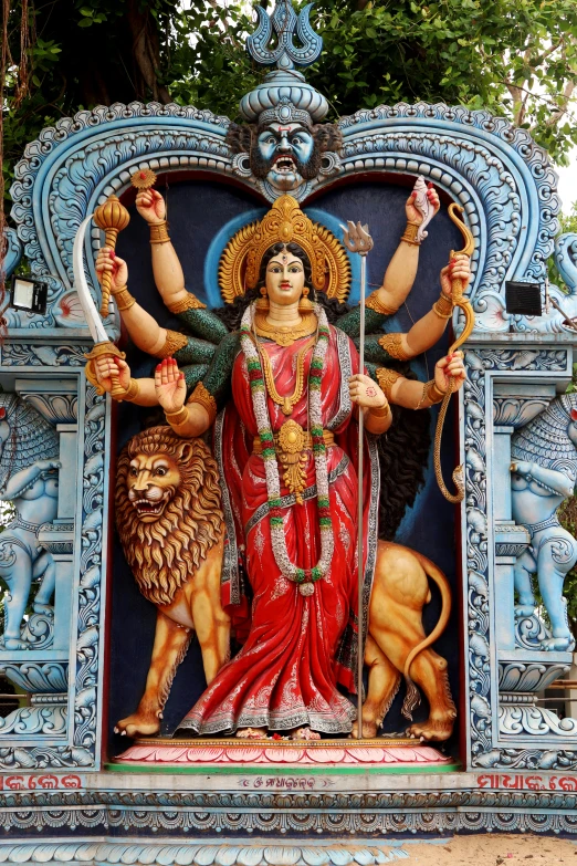 a close up of a statue of a woman with a lion, a statue, bengal school of art, dark goddess with six arms, ornate with fiery explosions, blue colored traditional wear, christian saint