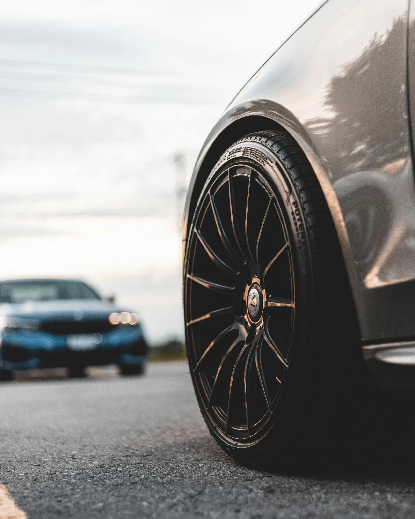 a car is parked on the side of the road, by Adam Marczyński, pexels contest winner, high detailed wheels, carbon fibers, male and female, thumbnail