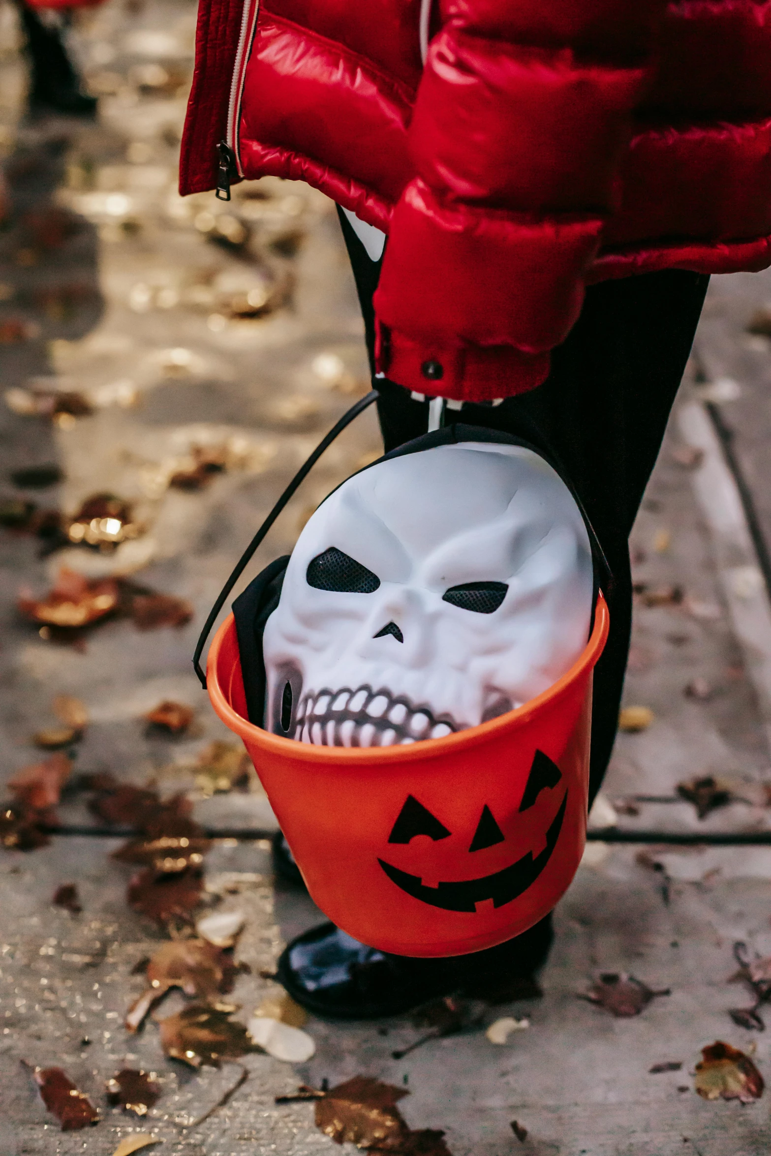 a person in a red jacket holding a trick bag, trick or treat, skull helmet, 2019 trending photo, close-up photograph