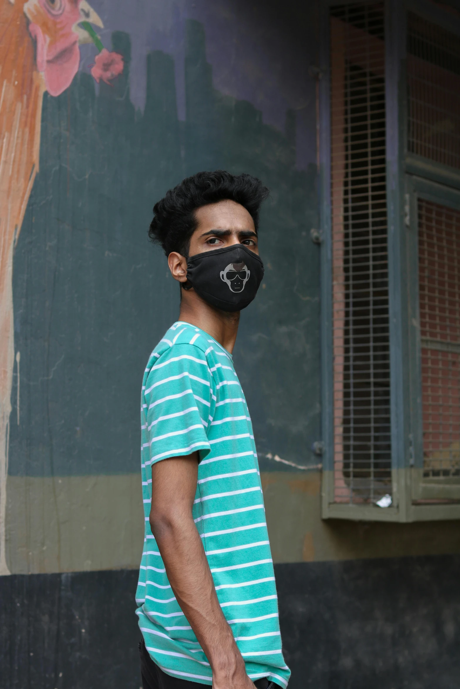 a man wearing a face mask walking down a street, by Rajesh Soni, renaissance, he is wearing a black t-shirt, male teenager, profile image, polluted