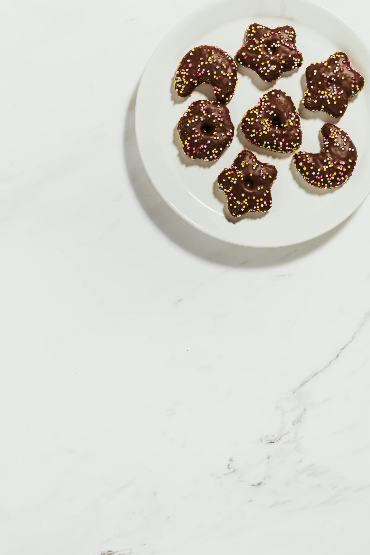 a white plate topped with chocolate covered strawberries, a digital rendering, trending on pexels, baroque, unrefined sparkling gold nugget, donut, matte surface, pictured from the shoulders up