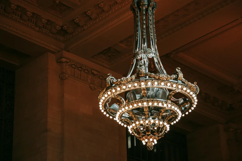 a chandelier hanging from the ceiling of a building, unsplash contest winner, neoclassicism, with sparkling gems on top, made of bronze, grand library, gallery lighting