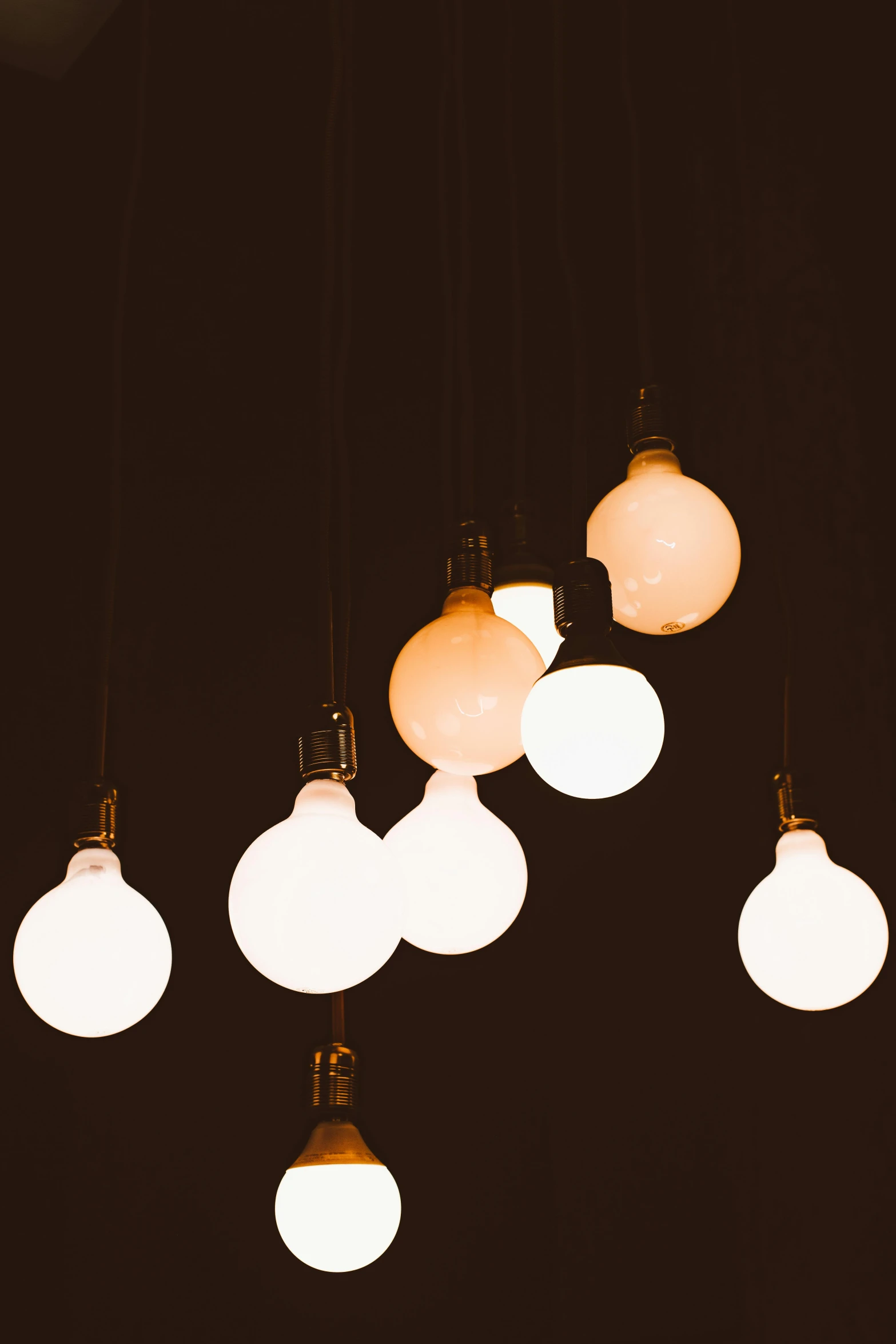 a bunch of light bulbs hanging from a ceiling, by Jesper Knudsen, unsplash, light and space, glowing orbs, soft shade, night light, plain background