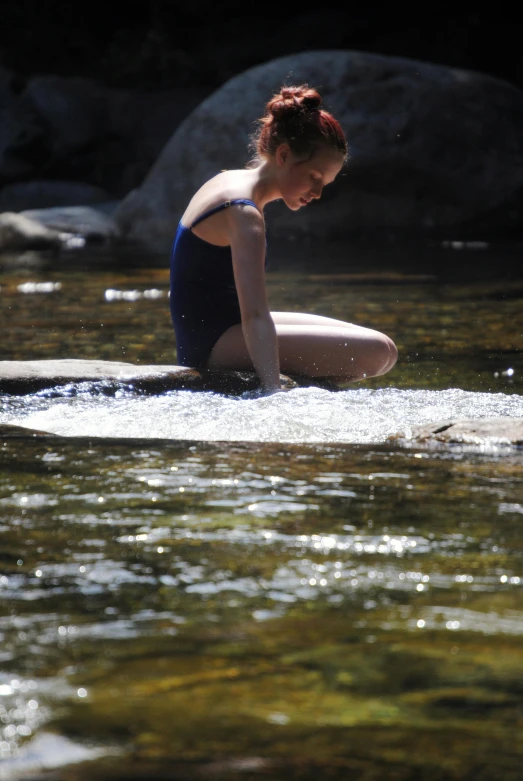 a woman sitting on a surfboard in a river, babbling brook, emma watson wearing a swimsuit, lots of sunlight, slide show