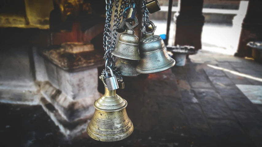 a bunch of bells hanging from a chain, by Daniel Lieske, pexels contest winner, hindu aesthetic, instagram post, dapped light, bronze
