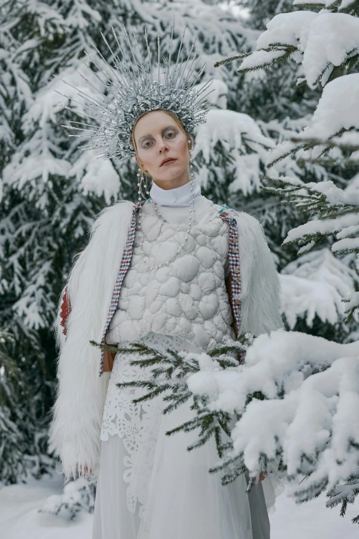 a woman in a white dress is standing in the snow, inspired by Louisa Matthíasdóttir, renaissance, white mohawk, high fashion themed, jeweled ornament over forehead, snowy trees