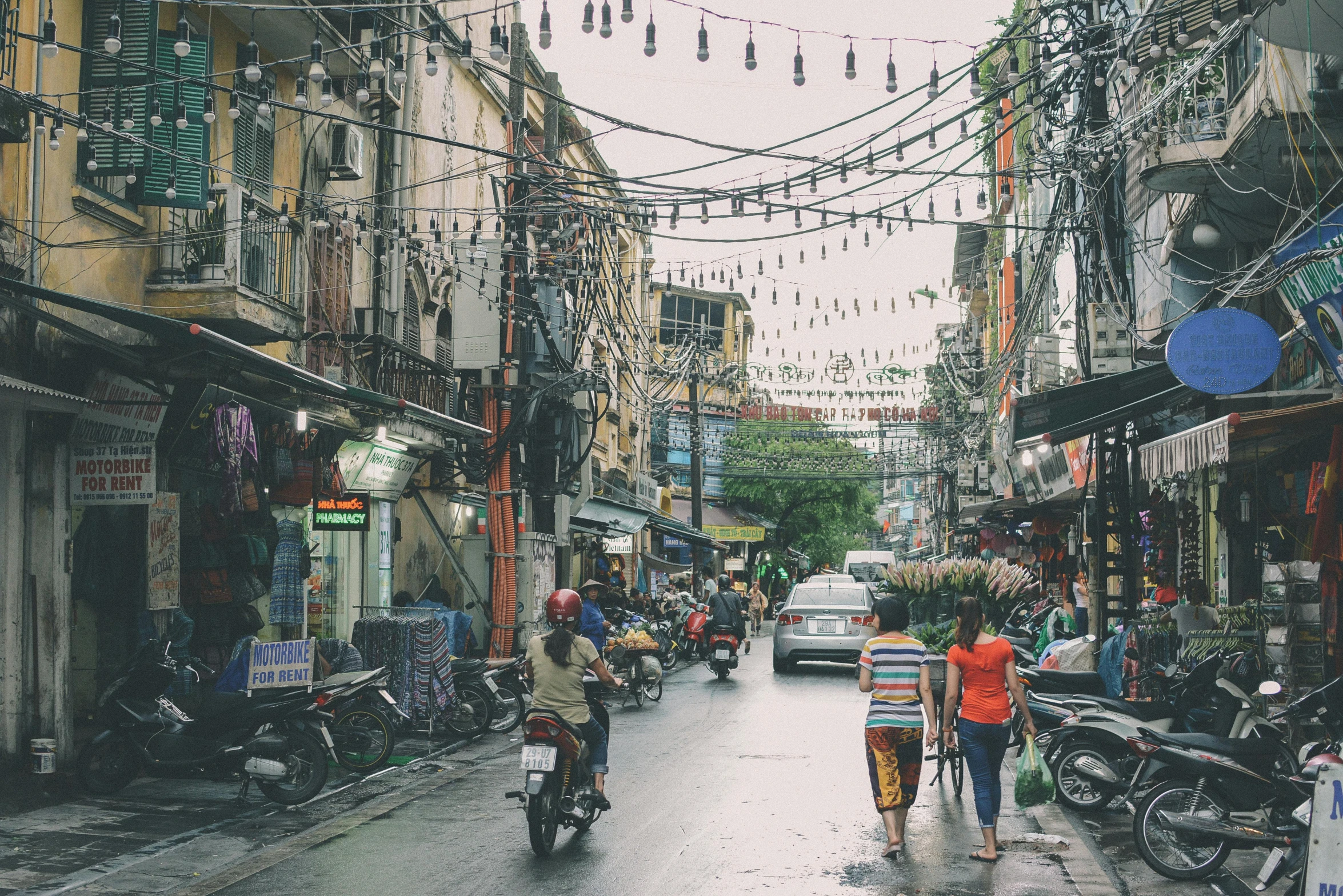 a couple of people that are walking down a street, a photo, unsplash contest winner, wet market street, cables everywhere, square, ilustration