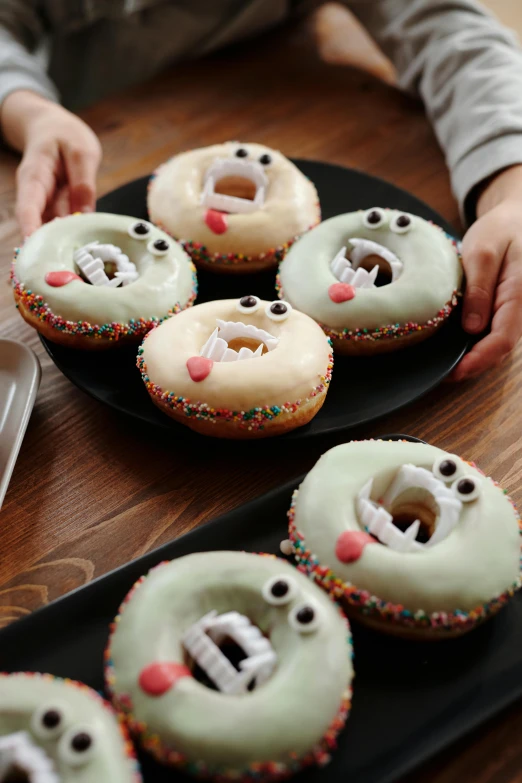 a black plate topped with donuts covered in frosting, by Murakami, gelatinous with teeth, 6 pack, round, kek