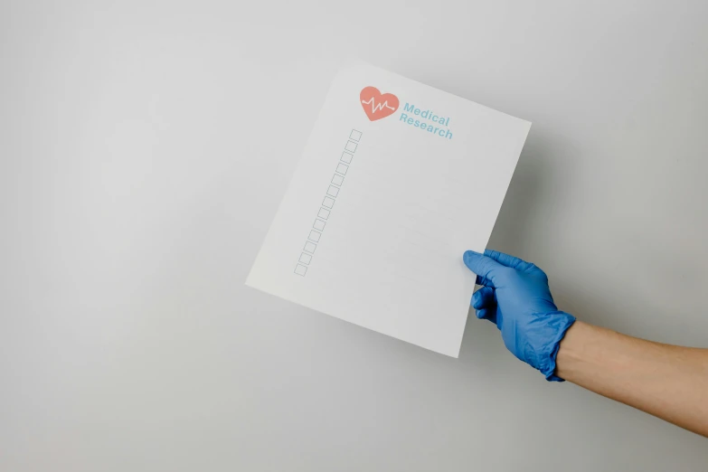 a person in blue gloves holding a piece of paper, medical photography, minimalist svg, heart operation, ai researcher