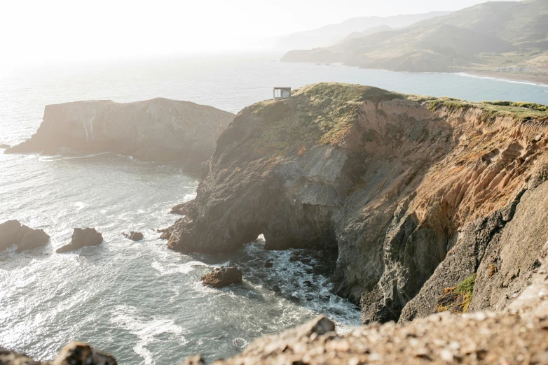 a man standing on top of a cliff next to the ocean, by Jessie Algie, pexels contest winner, bay area, 2 5 6 x 2 5 6 pixels, in style of joel meyerowitz, overlooking