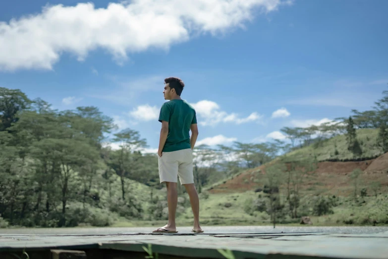 a man standing on top of a wooden platform, inspired by Fernando Amorsolo, pexels contest winner, wearing shorts and t shirt, avatar image, evergreen valley, sea - green and white clothes