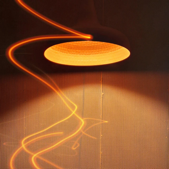 a close up of a light on a wall, by Jan Rustem, light and space, heated coils, orange lamp, whirling, warm lightning