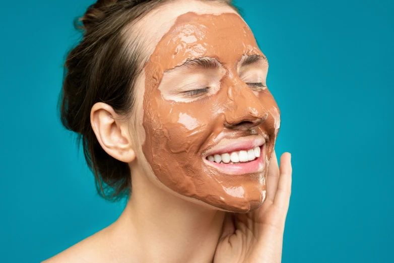 a woman with a mud mask on her face, by Julia Pishtar, trending on pexels, antipodeans, terracotta, fully chocolate, happy fashion model face, textured base ; product photos