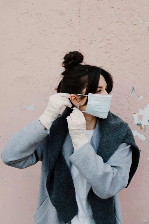 a woman wearing a face mask and gloves, a picture, by Emma Andijewska, trending on pexels, happening, wearing a duster coat, girl with messy bun hairstyle, asian woman, with wires and bandages